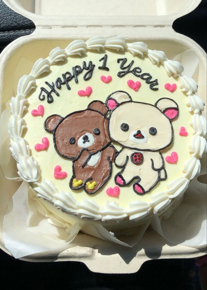 White anniversary cake featuring two cute cartoon bears and Happy 1 Year text.
