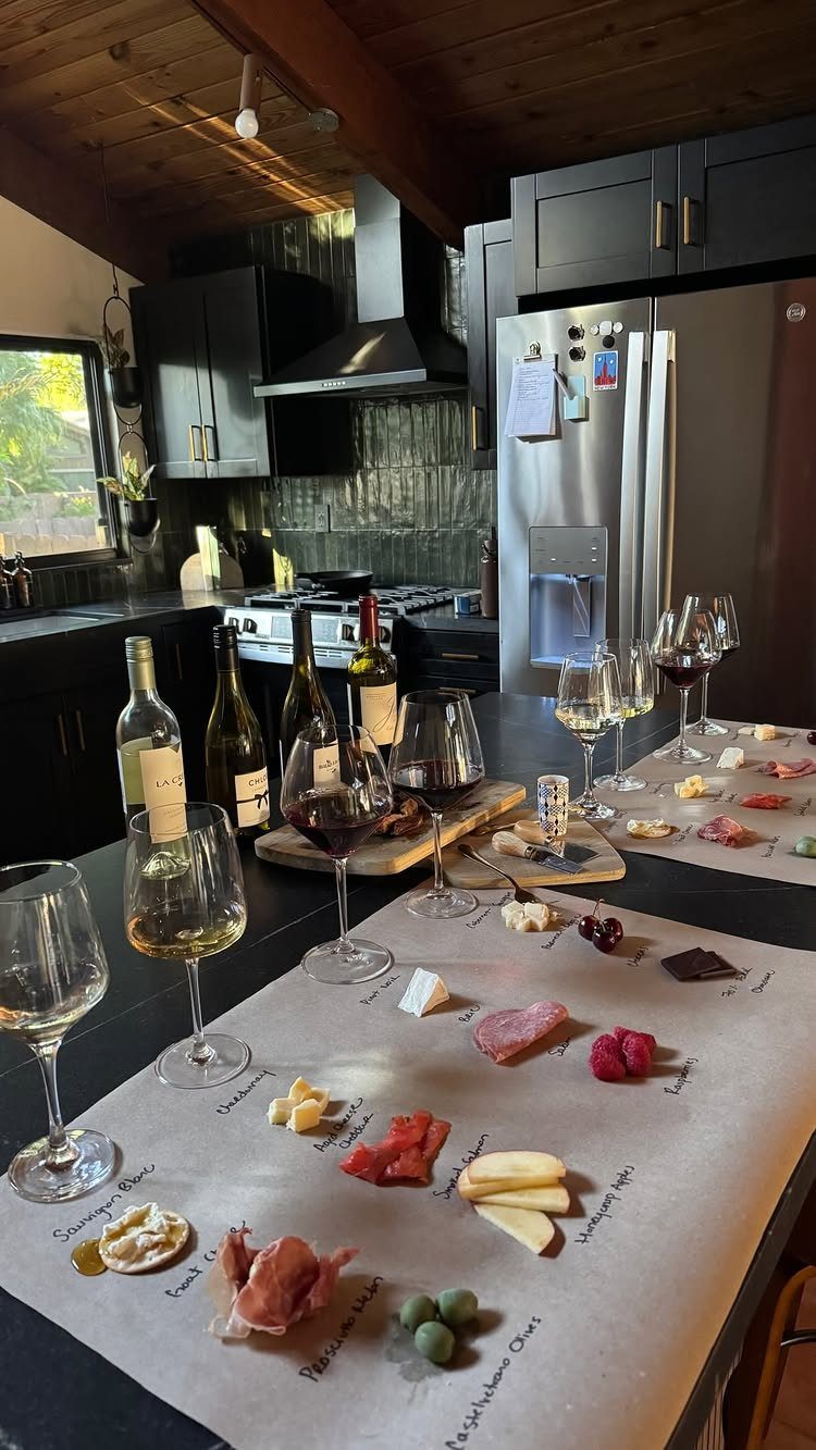 Charcuterie board with cheeses and meats paired with glasses of red and white wine.