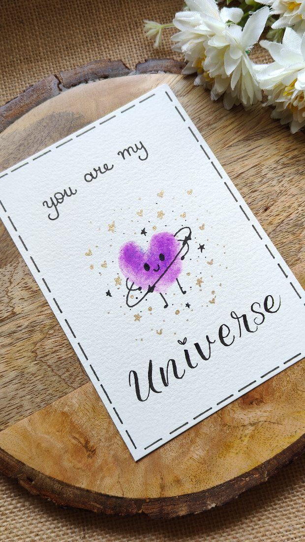 32 Anniversary Card Ideas to Make at Home (Photos Inside) 2 Handwritten anniversary card with a purple watercolor heart and the quote you are my Universe.