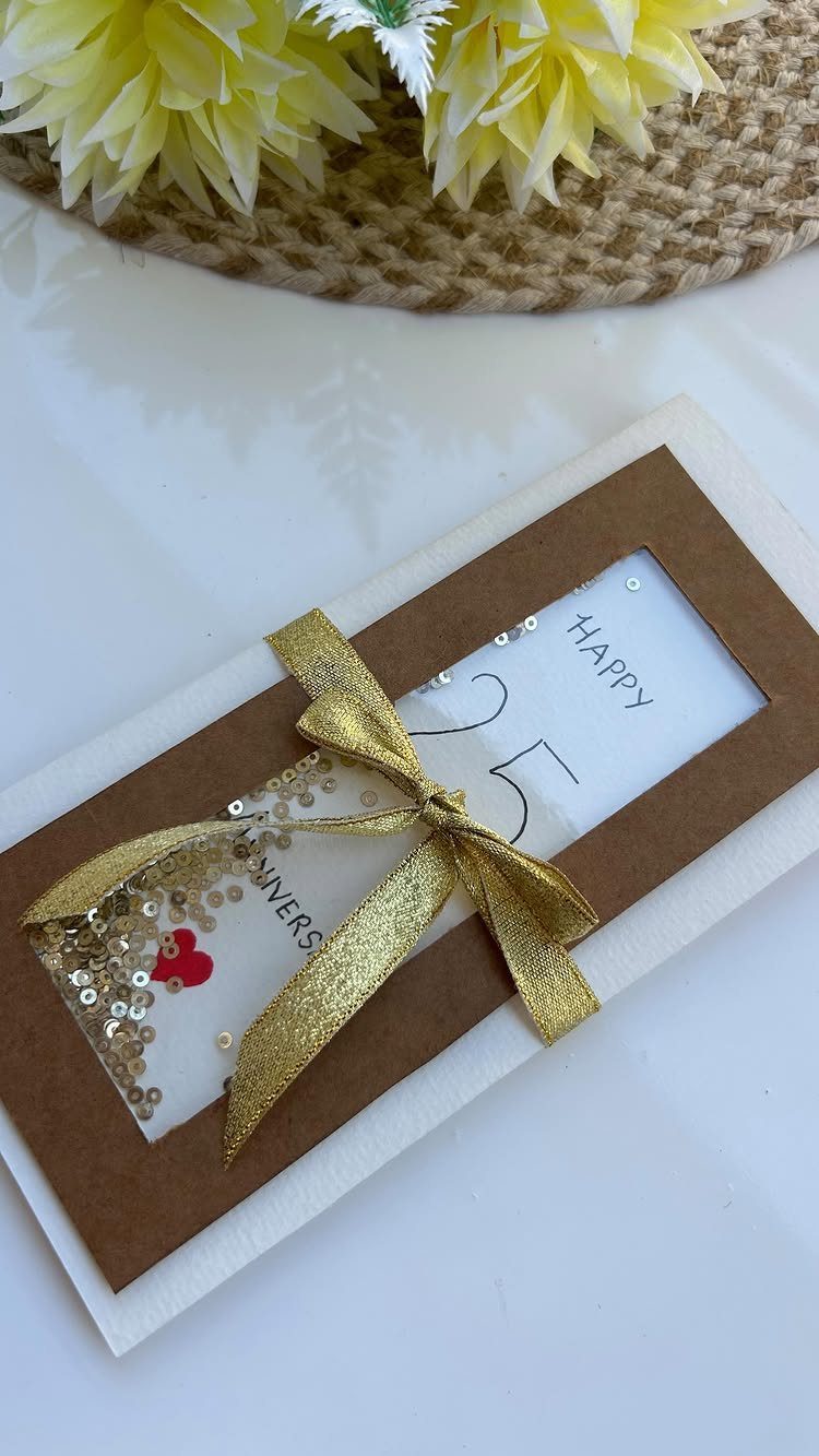 32 Anniversary Card Ideas to Make at Home (Photos Inside) 3 Handmade 25th anniversary card with gold ribbon, sequins, and handwritten text.