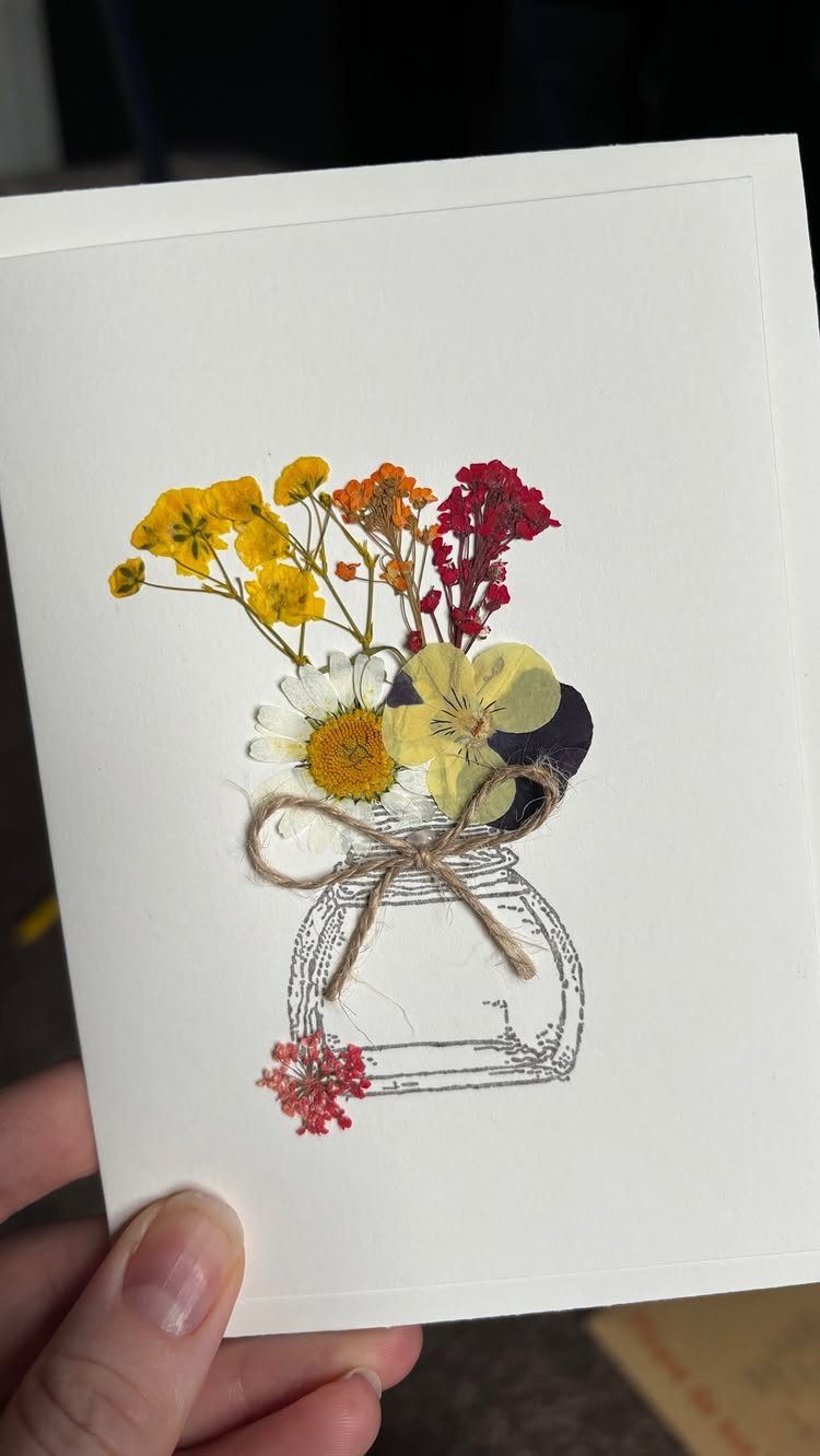 32 Anniversary Card Ideas to Make at Home (Photos Inside) 8 Pressed colorful flowers arranged in a drawn mason jar on a white card.