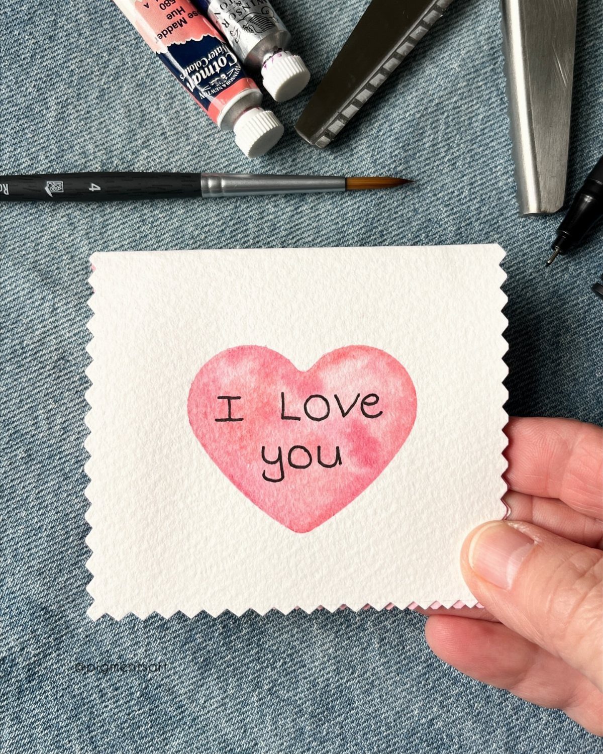 32 Anniversary Card Ideas to Make at Home (Photos Inside) 11 Watercolor card with a pink heart and I Love you text on denim background