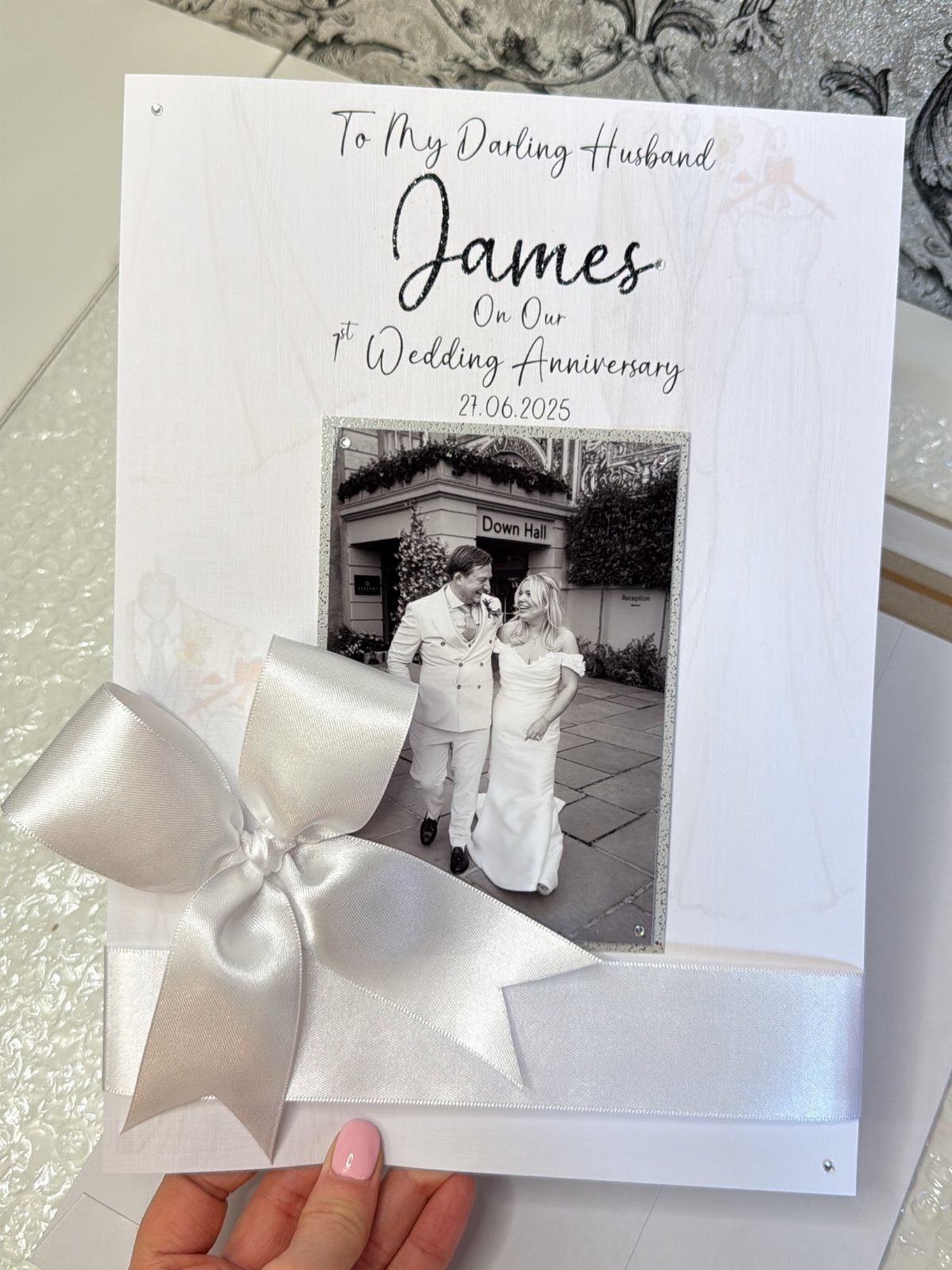 32 Anniversary Card Ideas to Make at Home (Photos Inside) 7 White anniversary card with a wedding photo and a large white satin bow.