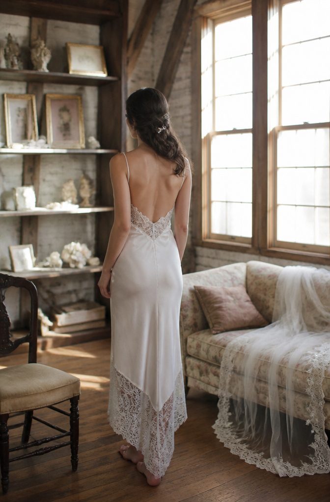 A bride wearing a vintage lace-trimmed slip in a quaint loft.