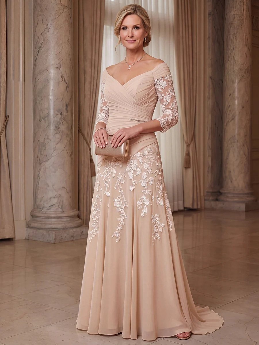 Woman in a blush lace gown with floral embroidery and a gold clutch.