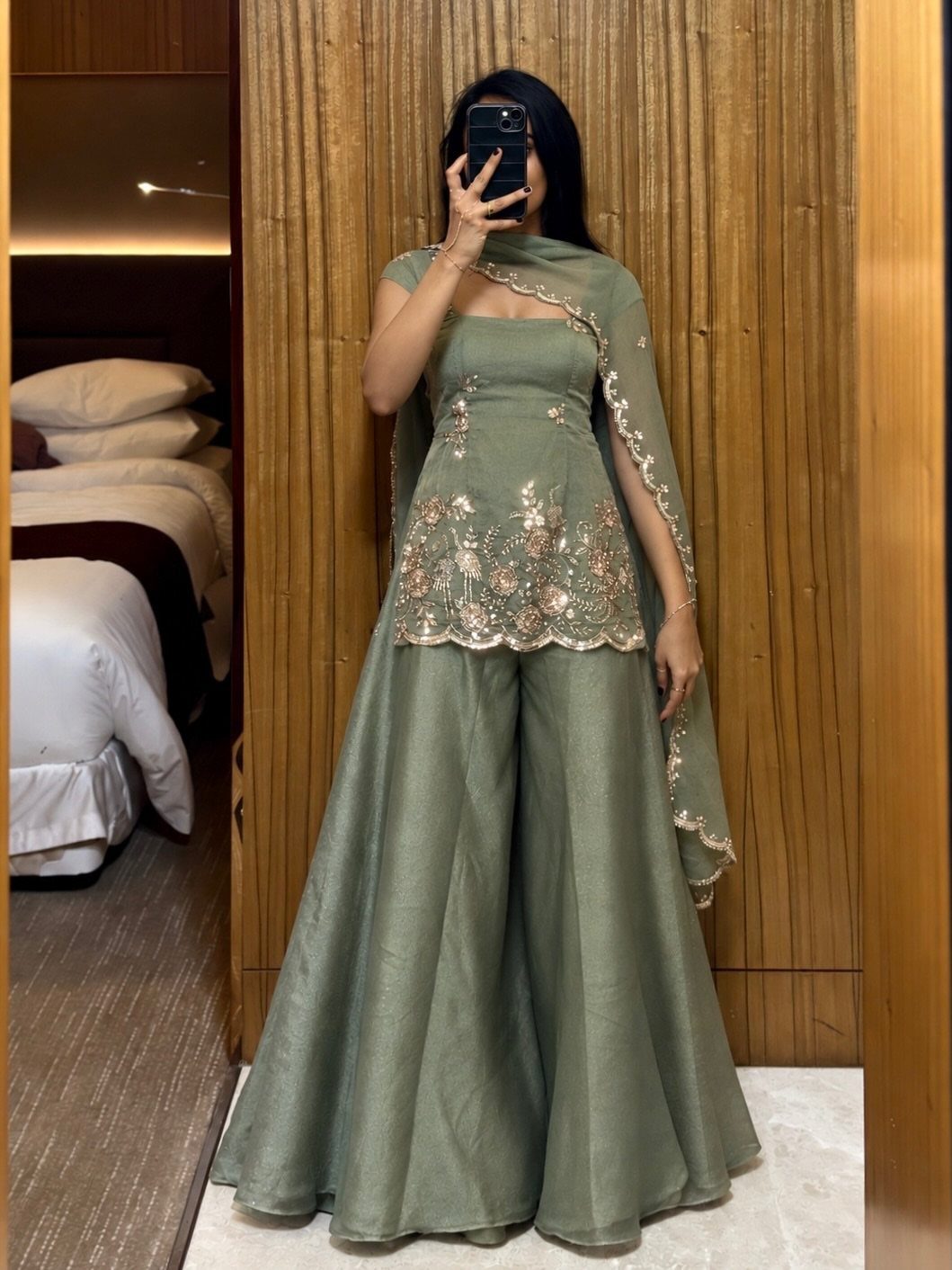 Woman in sage green embroidered Indian tunic and wide-leg palazzo pants for wedding guest