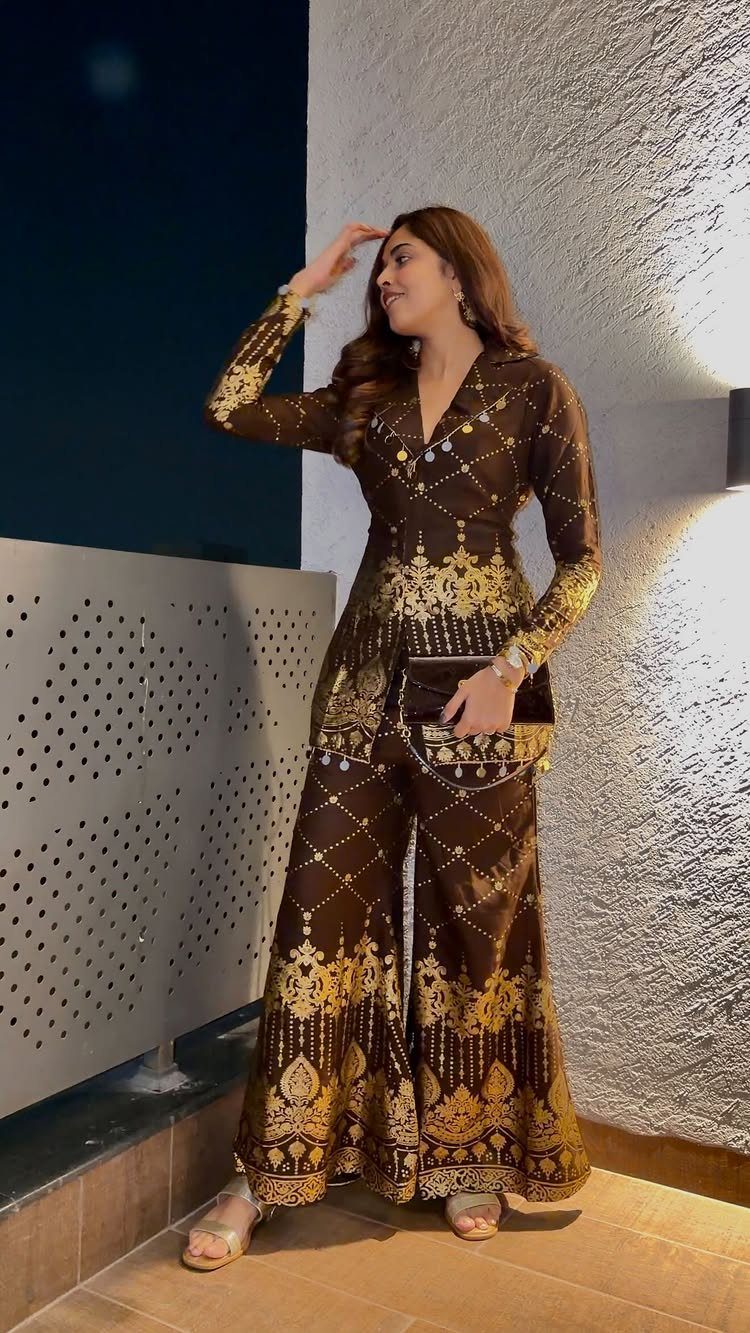 Woman wearing a brown and gold embroidered sharara set with wide-legged trousers.