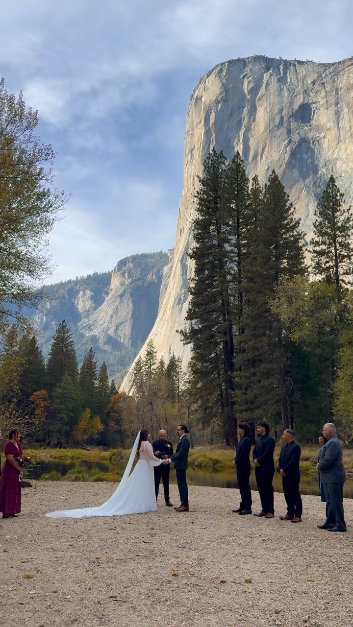 Wedding ceremony with a bride and groom before a massive granite cliff face.