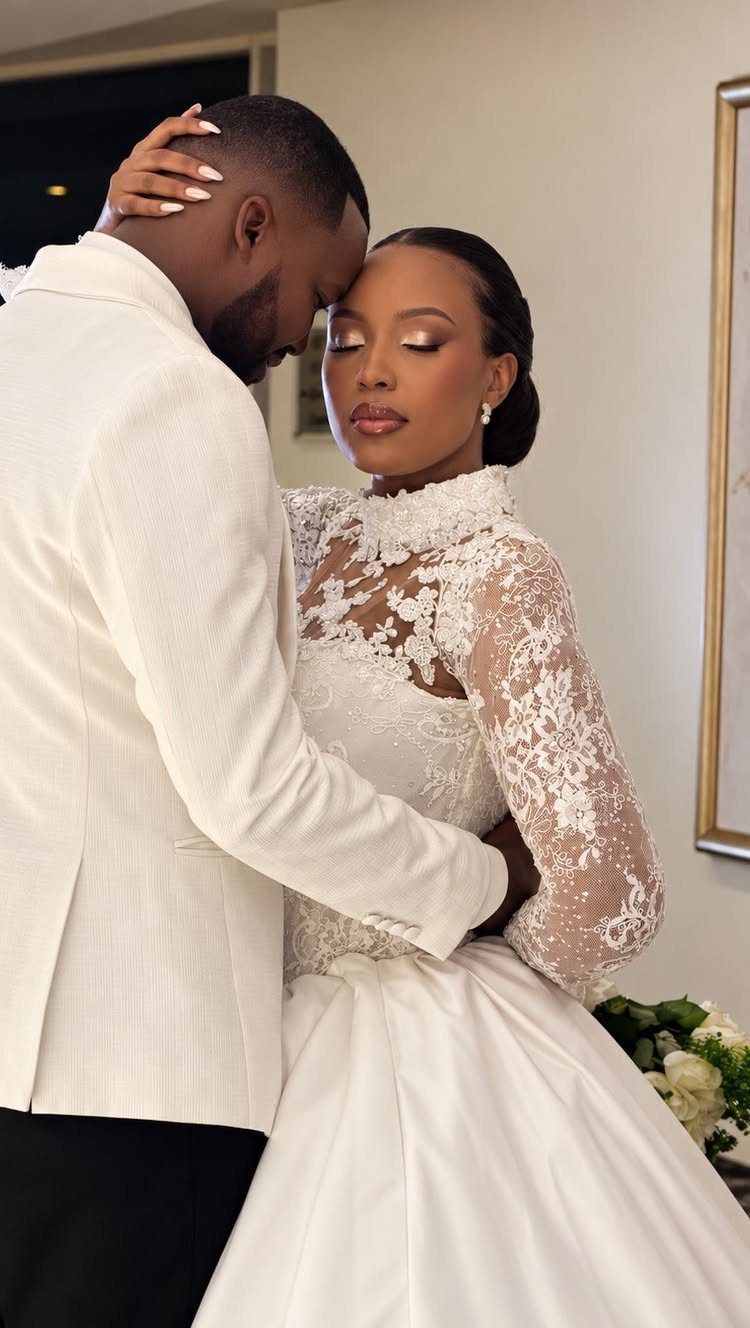 Claire Wedding Dress Styles: 11 Gowns to Inspire Your Look 9 Bride in a high-neck lace wedding gown embracing a groom in a white blazer.