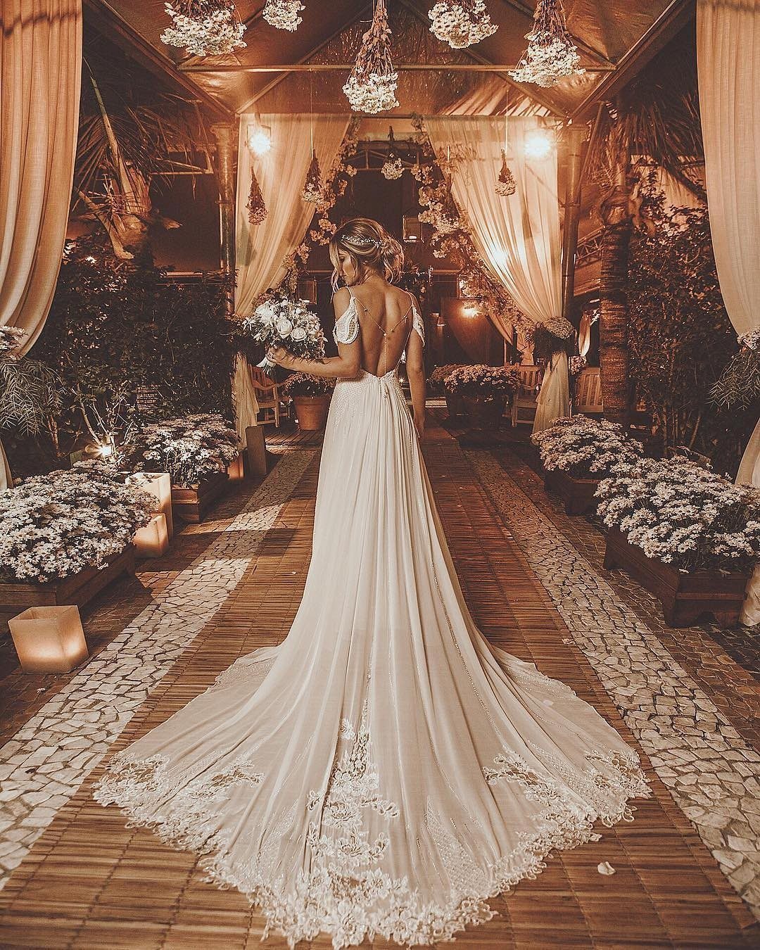 Claire Wedding Dress Styles: 11 Gowns to Inspire Your Look 4 Woman in a backless white wedding gown with a long lace train in a garden