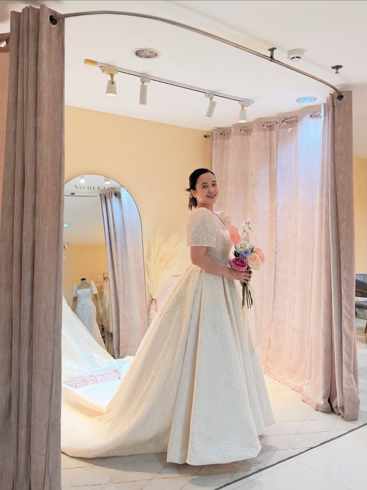 Claire Wedding Dress Styles: 11 Gowns to Inspire Your Look 12 Woman in a sparkling ivory wedding gown holding a colorful floral bouquet.