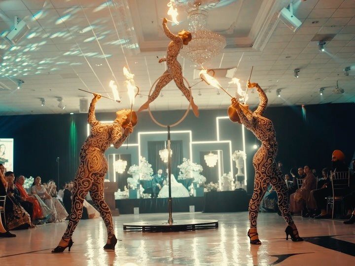 Circus performers with fire torches and an aerial hoop at a wedding reception.