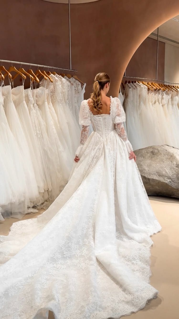 Woman wearing a white lace princess wedding dress with a full skirt and long train.