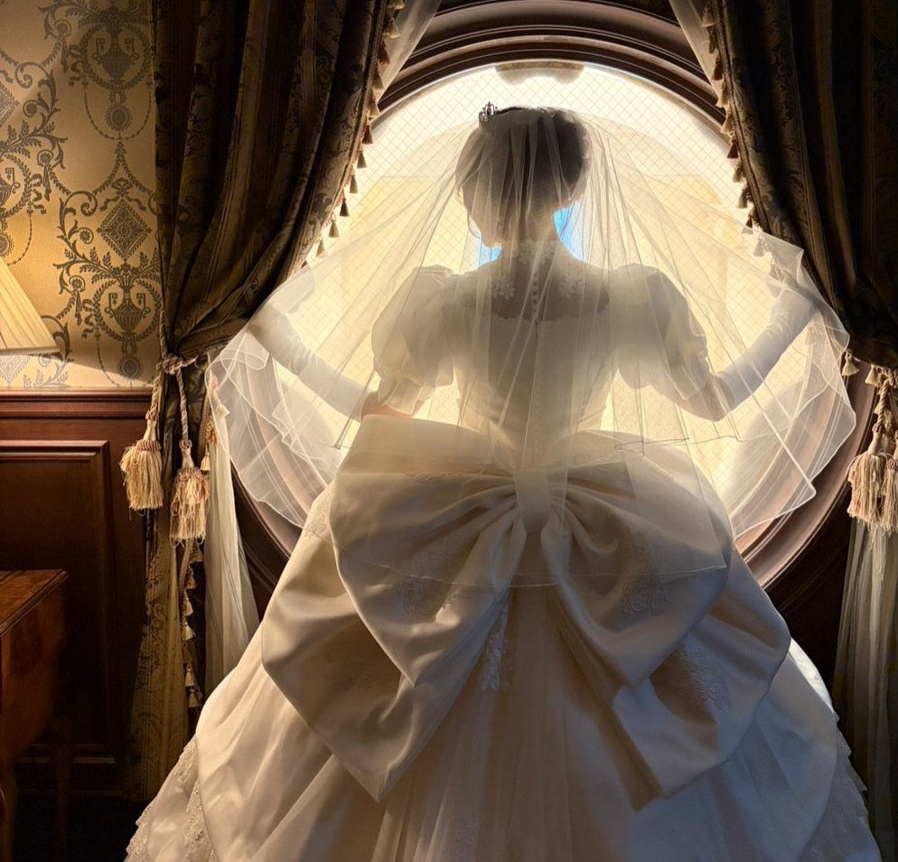 Woman in a white wedding gown with a large bow and sheer veil