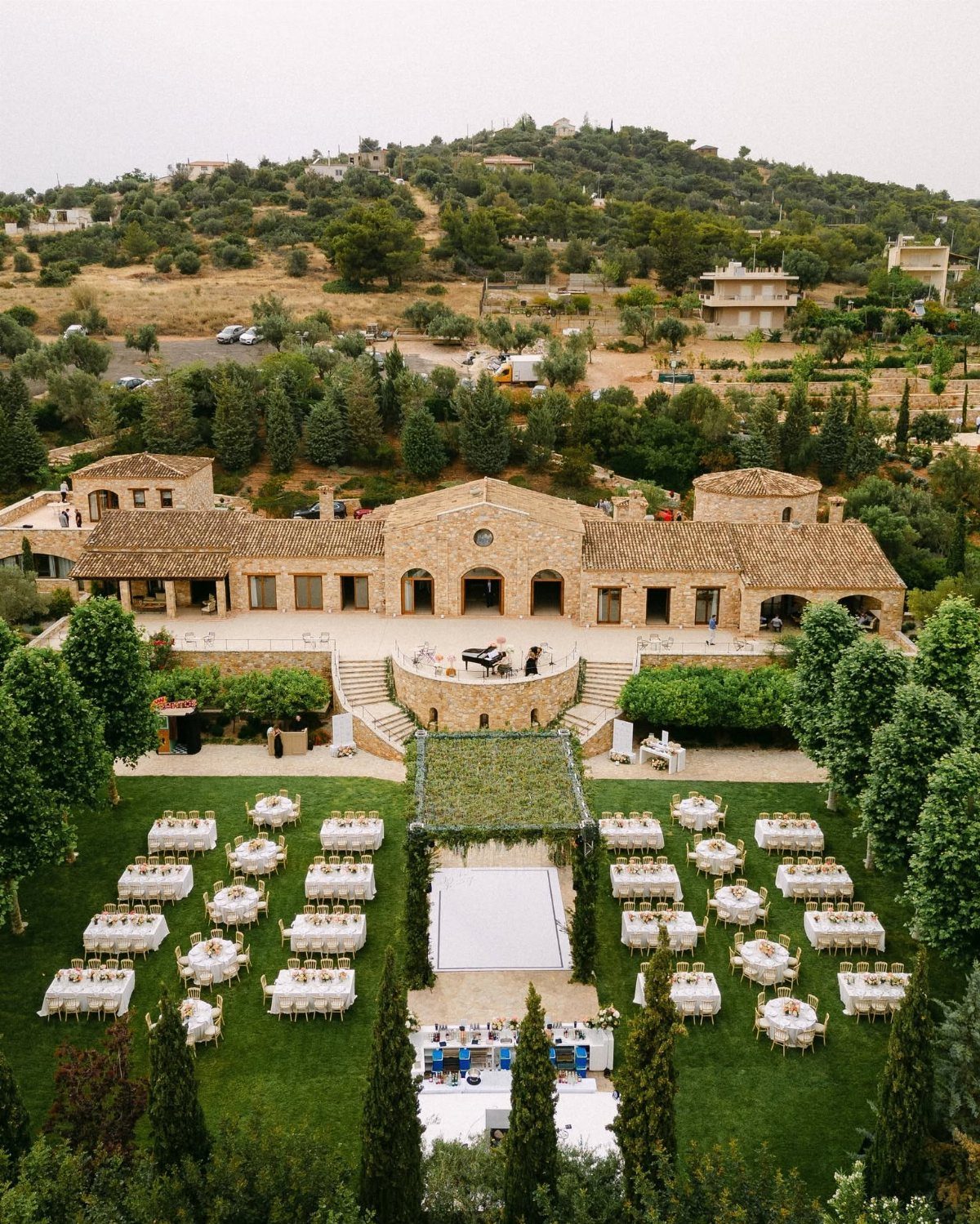Stone Byzantine estate with outdoor wedding reception tables on a lush green lawn