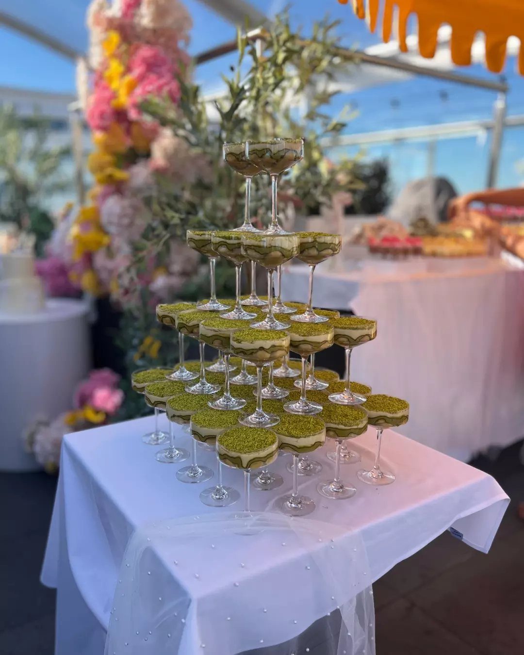 Green Bridal Shower Ideas: 10 Eco-Friendly Party Picks 7 Champagne glass tower filled with green drinks on a white table outdoors.