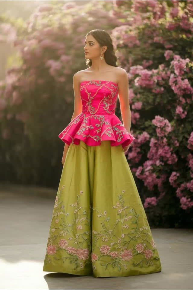 Woman wearing a pink peplum crop top and olive green floral embroidered palazzos.