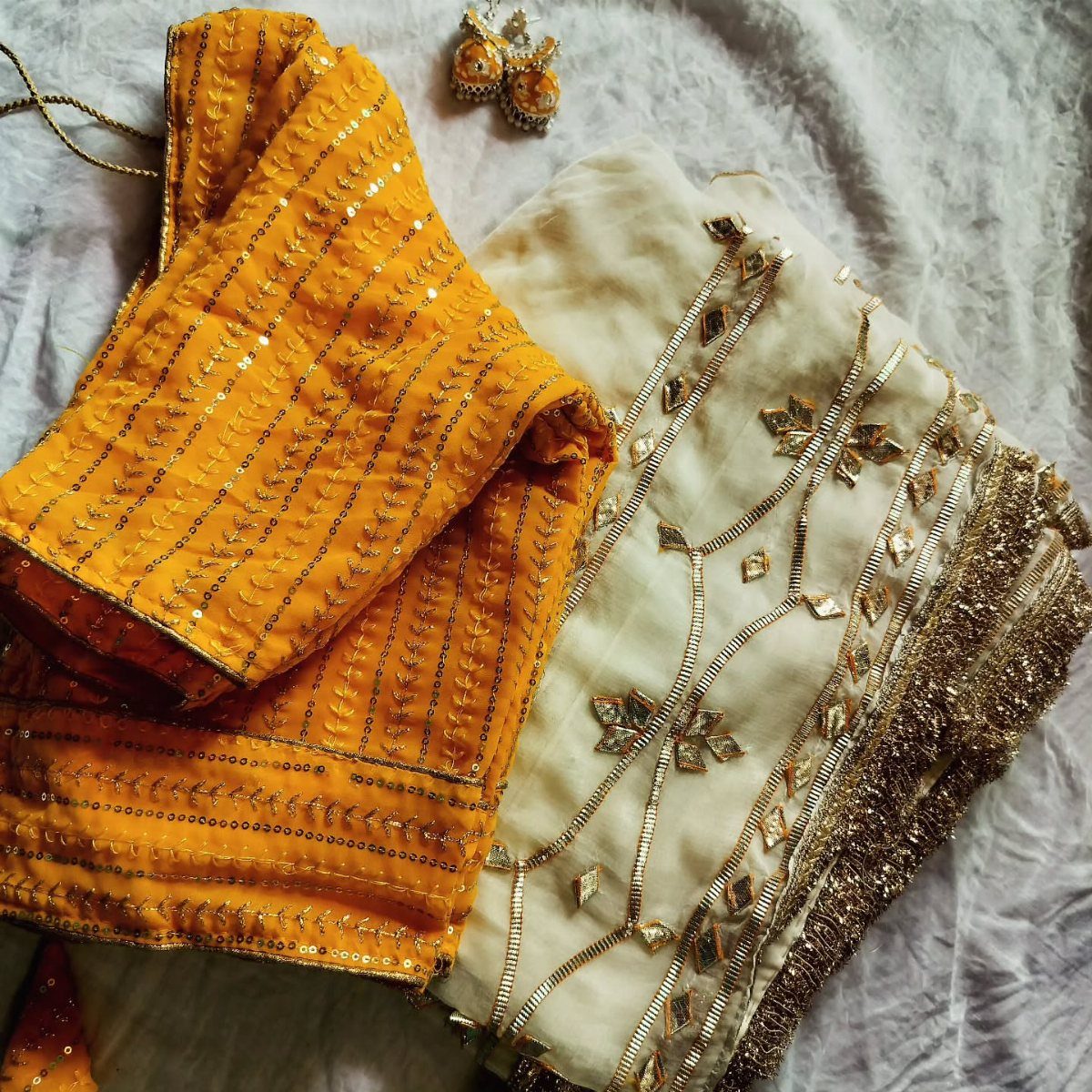 Yellow and white traditional Indian outfit with gold gota patti and mirror embroidery.