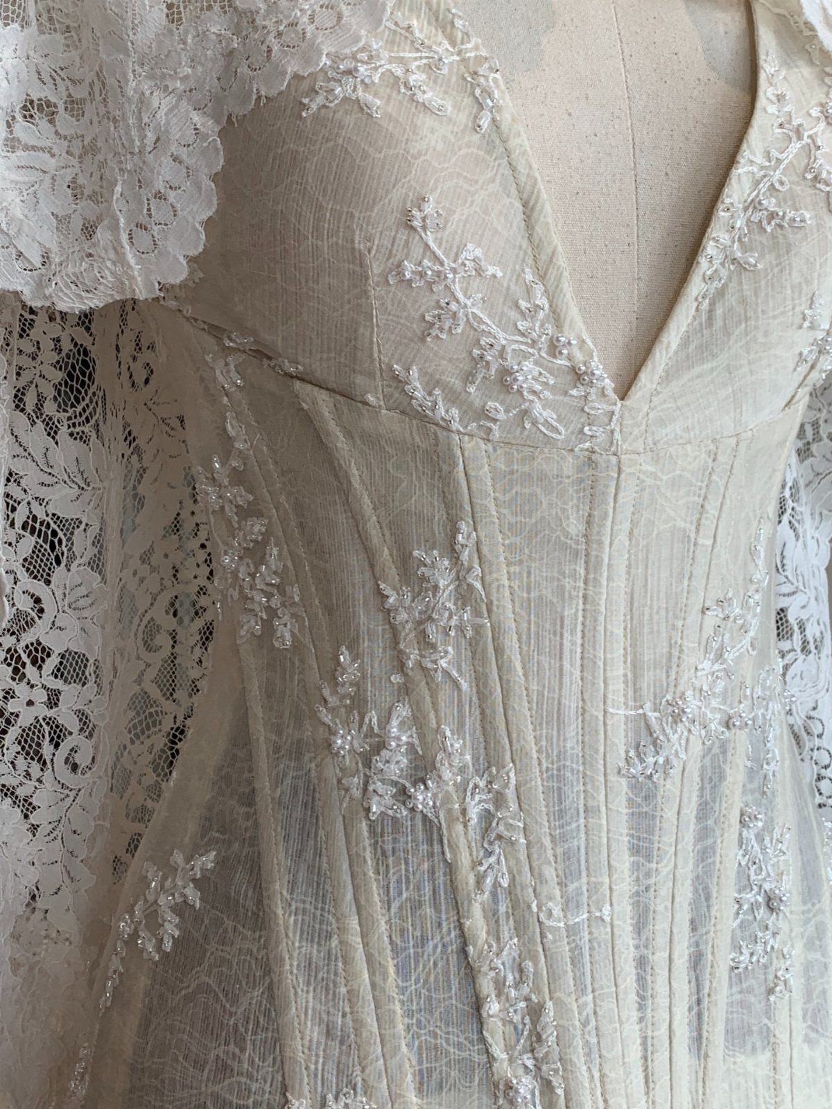 White lace wedding dress corset with sheer panels and floral embroidery on a mannequin