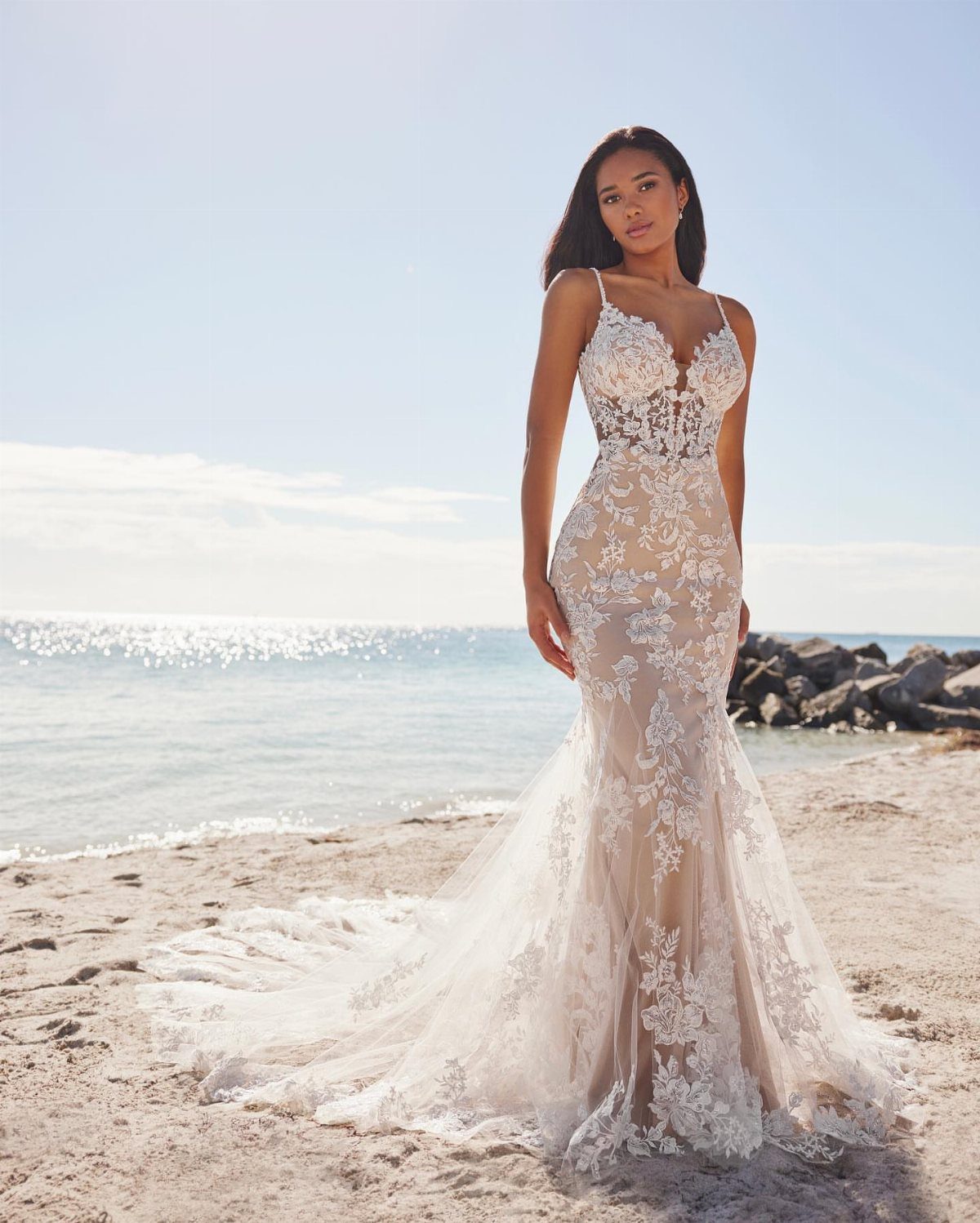 Woman in a white lace wedding dress with a sheer pointed heart-shaped corset bodice.
