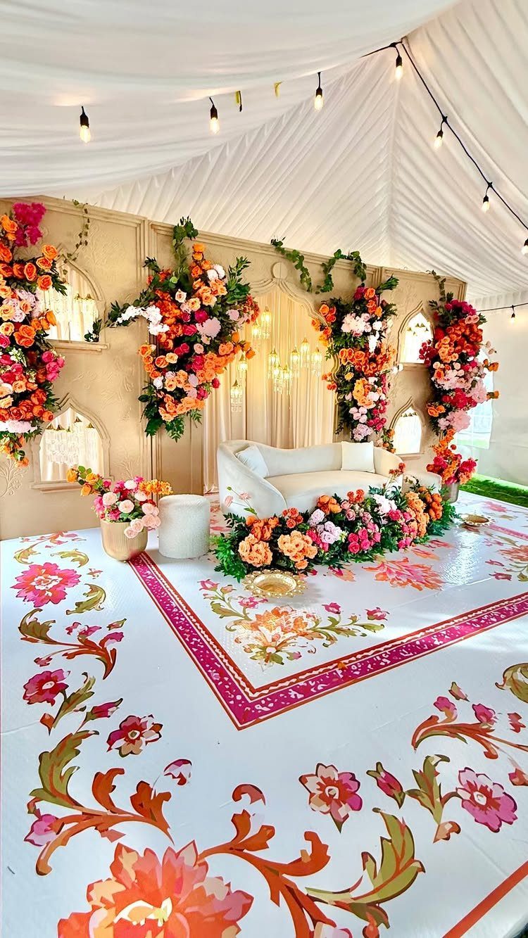 13 Mehndi Decoration Ideas for Outdoor Parties 2 Floral event decoration with a white sofa and colorful flower arrangements under a tent