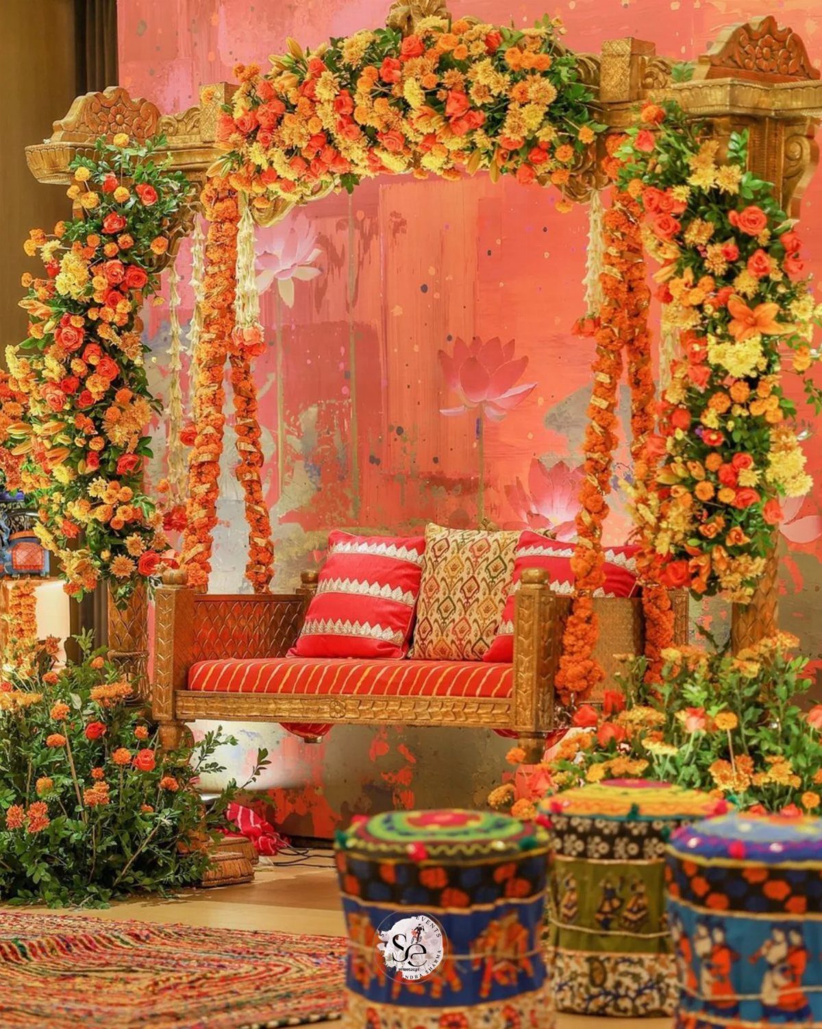 13 Mehndi Decoration Ideas for Outdoor Parties 9 Decorated wooden garden swing with orange flowers and red cushions for a mehndi event