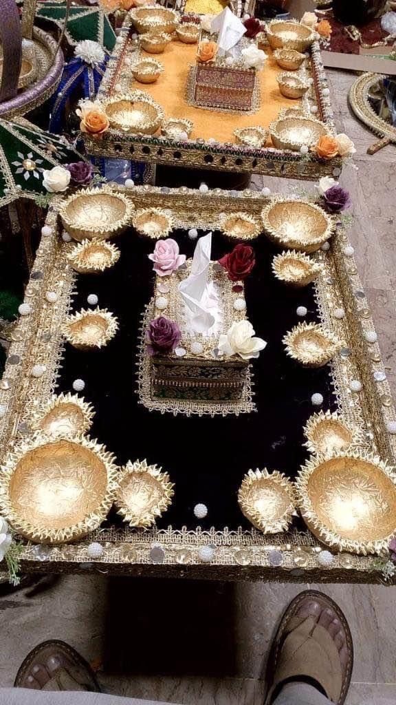 Black velvet mehndi tray with gold bowls and a floral decorative box.