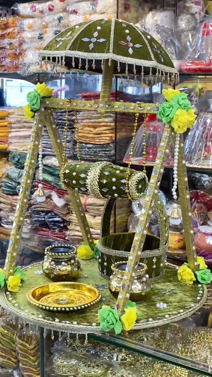 Green velvet mehndi platter with a miniature dhol, umbrella, and gold pots.