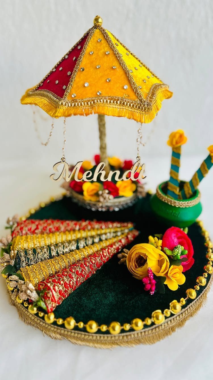 Decorative mehndi platter with a yellow umbrella and gold lettering saying Mehndi