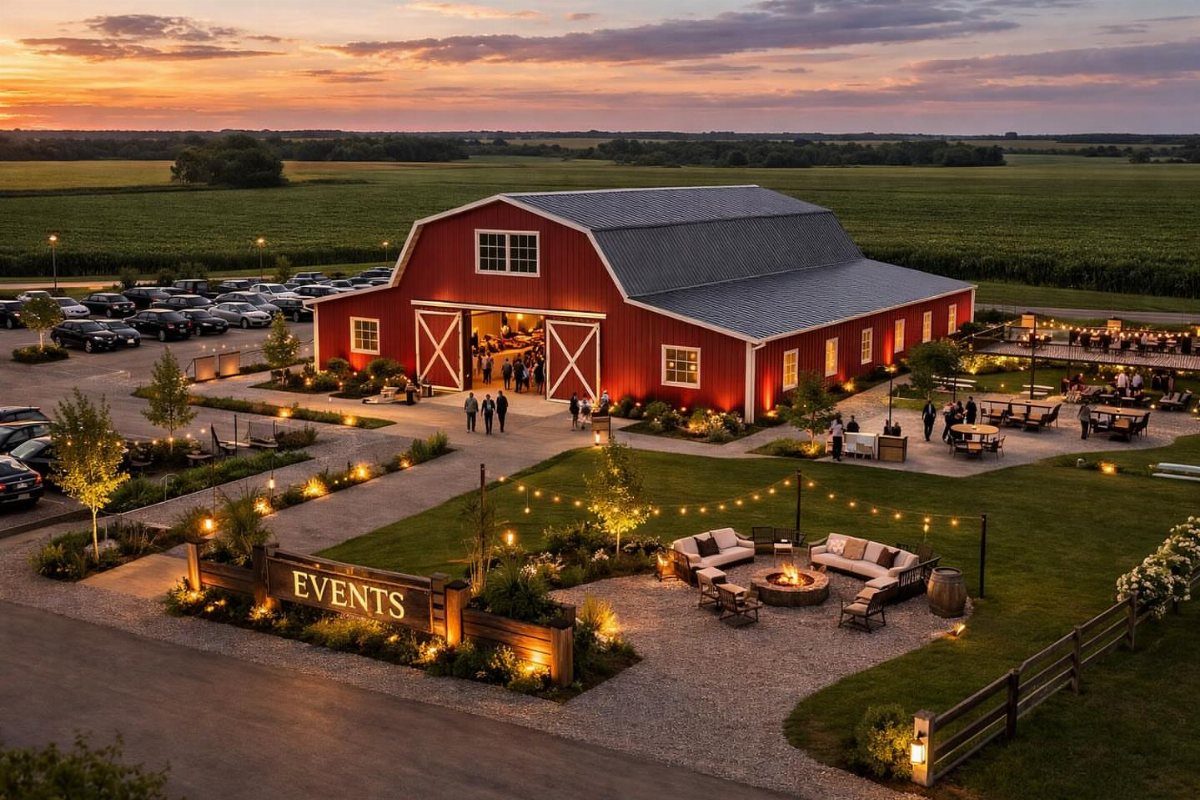 Red barn event venue with an outdoor patio, fire pit, and string lights at sunset.