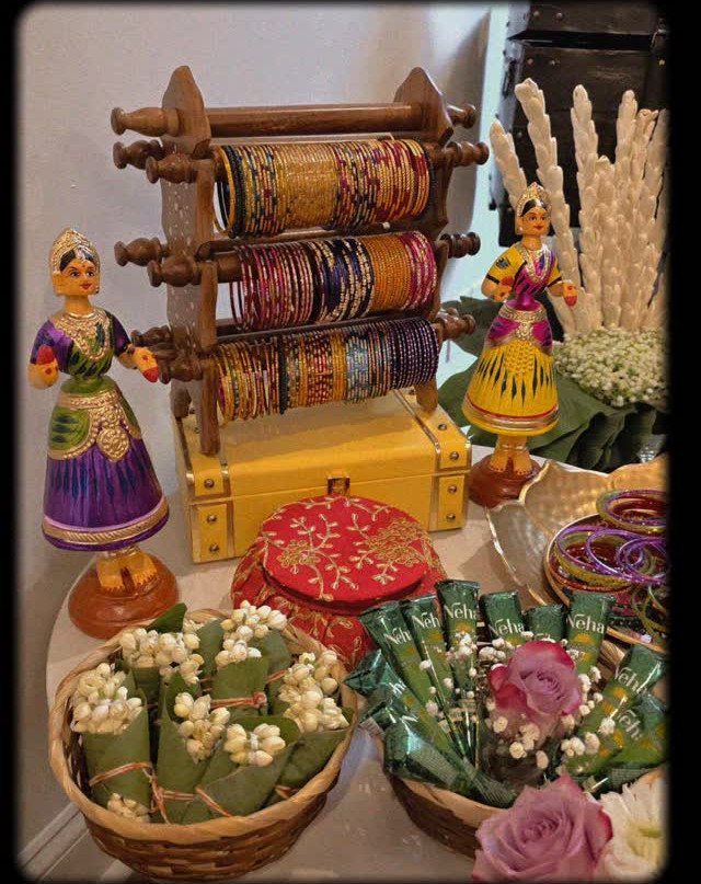 15 Seemantham Decoration Ideas for a Joyful Baby Shower 12 Traditional Indian display with colorful bangles, figurines, and baskets of fresh jasmine flowers.