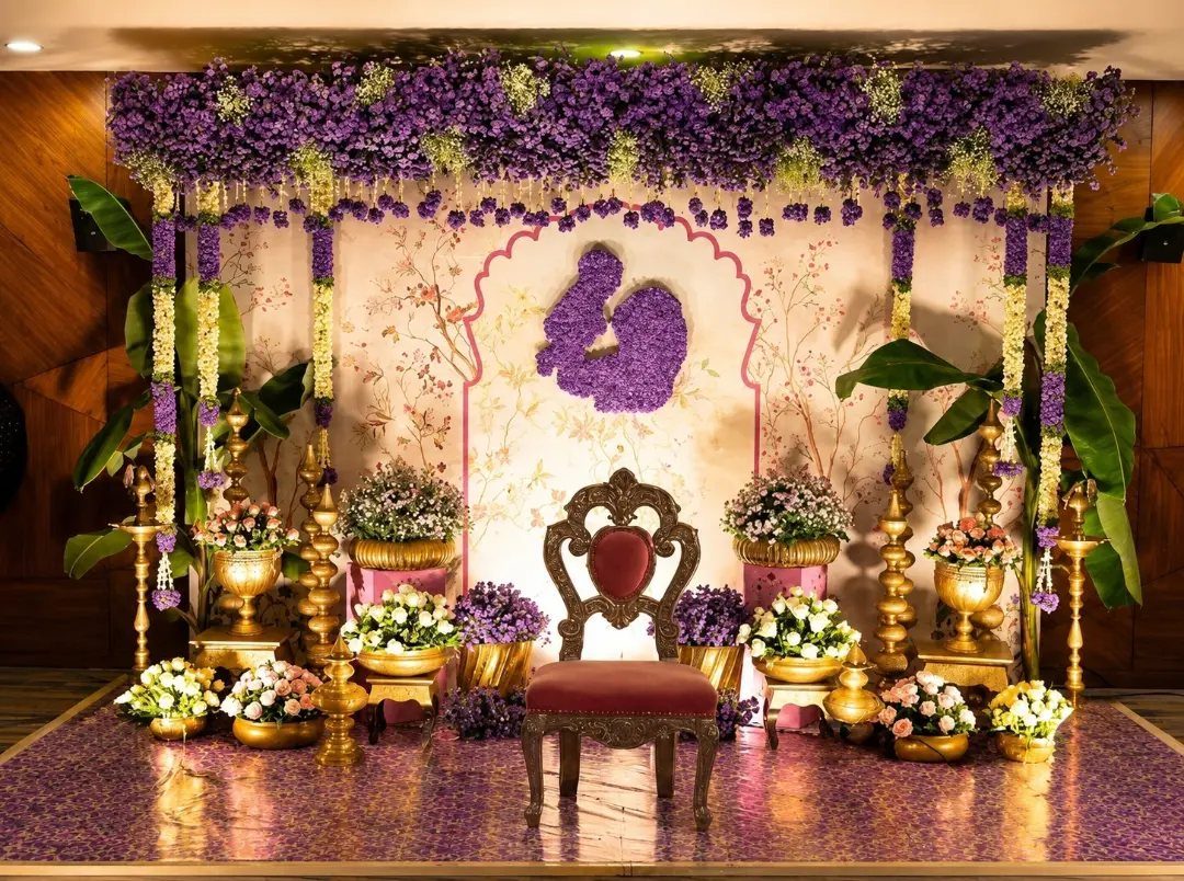 15 Seemantham Decoration Ideas for a Joyful Baby Shower 14 Festive event backdrop with purple flowers, ornate red chair, and traditional gold vases.