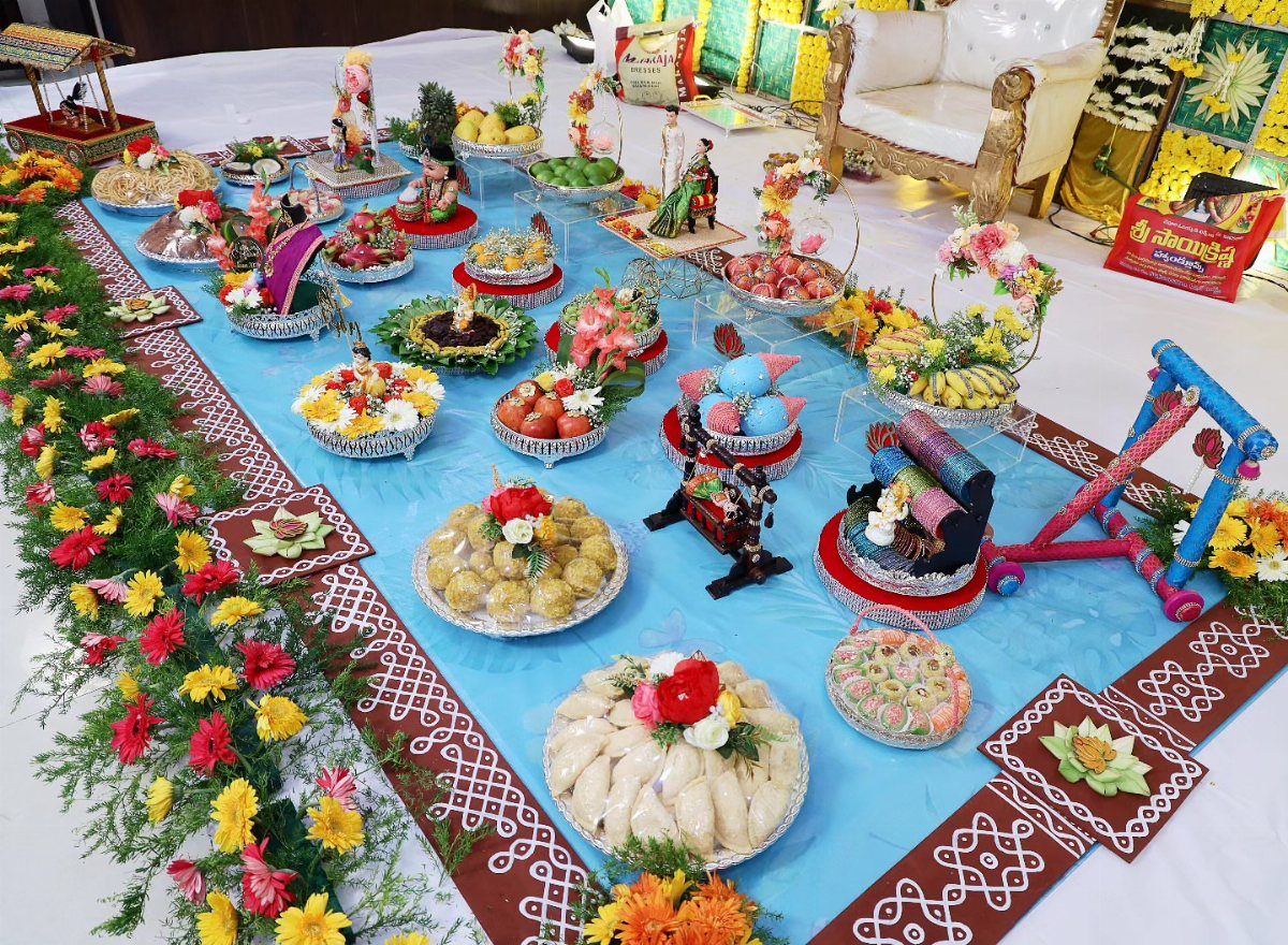 15 Seemantham Decoration Ideas for a Joyful Baby Shower 7 Traditional food and sweet displays on a blue floor with floral borders.