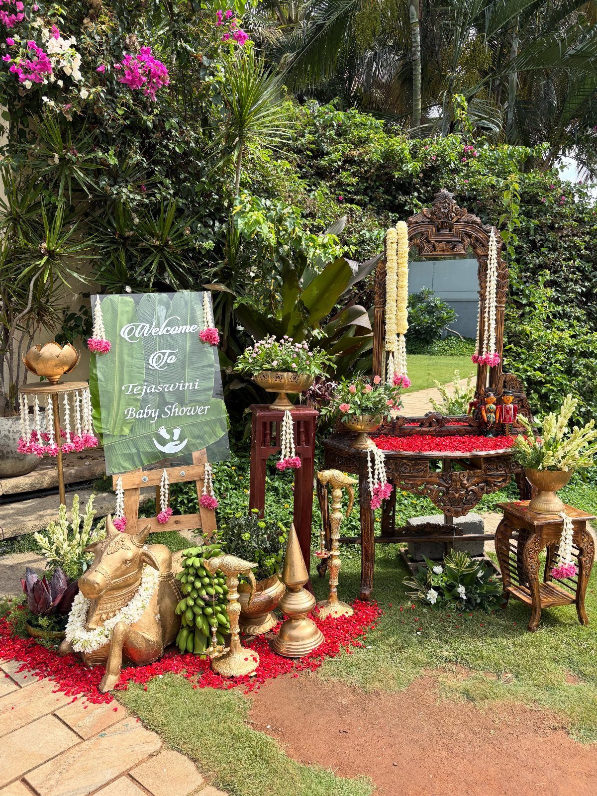 15 Seemantham Decoration Ideas for a Joyful Baby Shower 8 Traditional baby shower decoration with brass lamps, carved wooden furniture, and floral garlands.