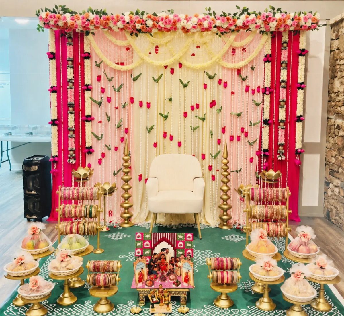 15 Seemantham Decoration Ideas for a Joyful Baby Shower 6 Festive Seemantham decoration with floral backdrop, white armchair, and colorful bangle displays.