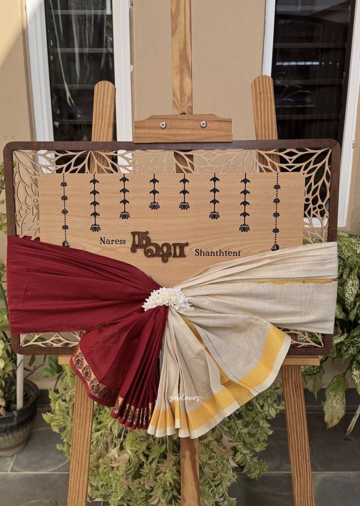 15 Seemantham Decoration Ideas for a Joyful Baby Shower 13 Wooden easel with carved board draped in red and cream traditional fabrics