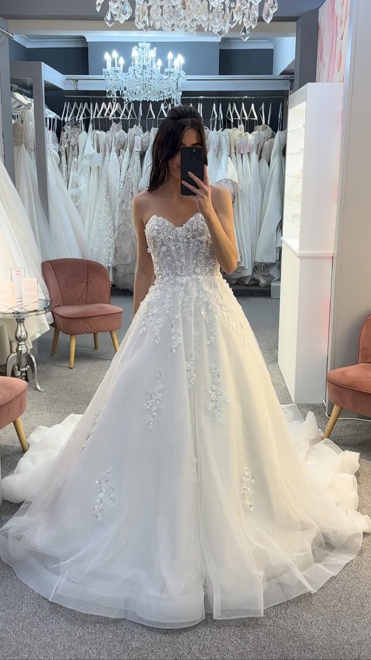 Woman in a white ball gown wedding dress with a sweetheart neckline and full skirt.