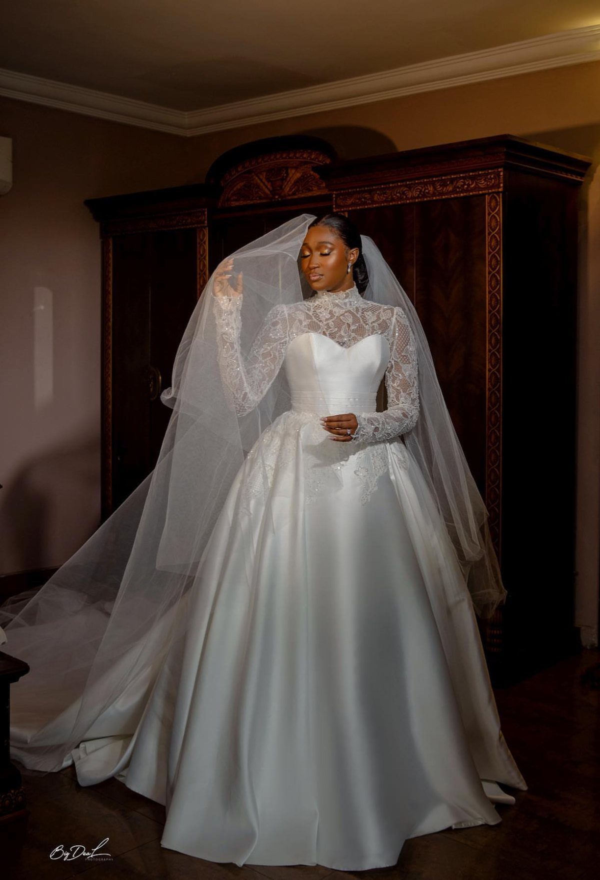 Woman in a white wedding gown with illusion sweetheart neckline and full skirt.