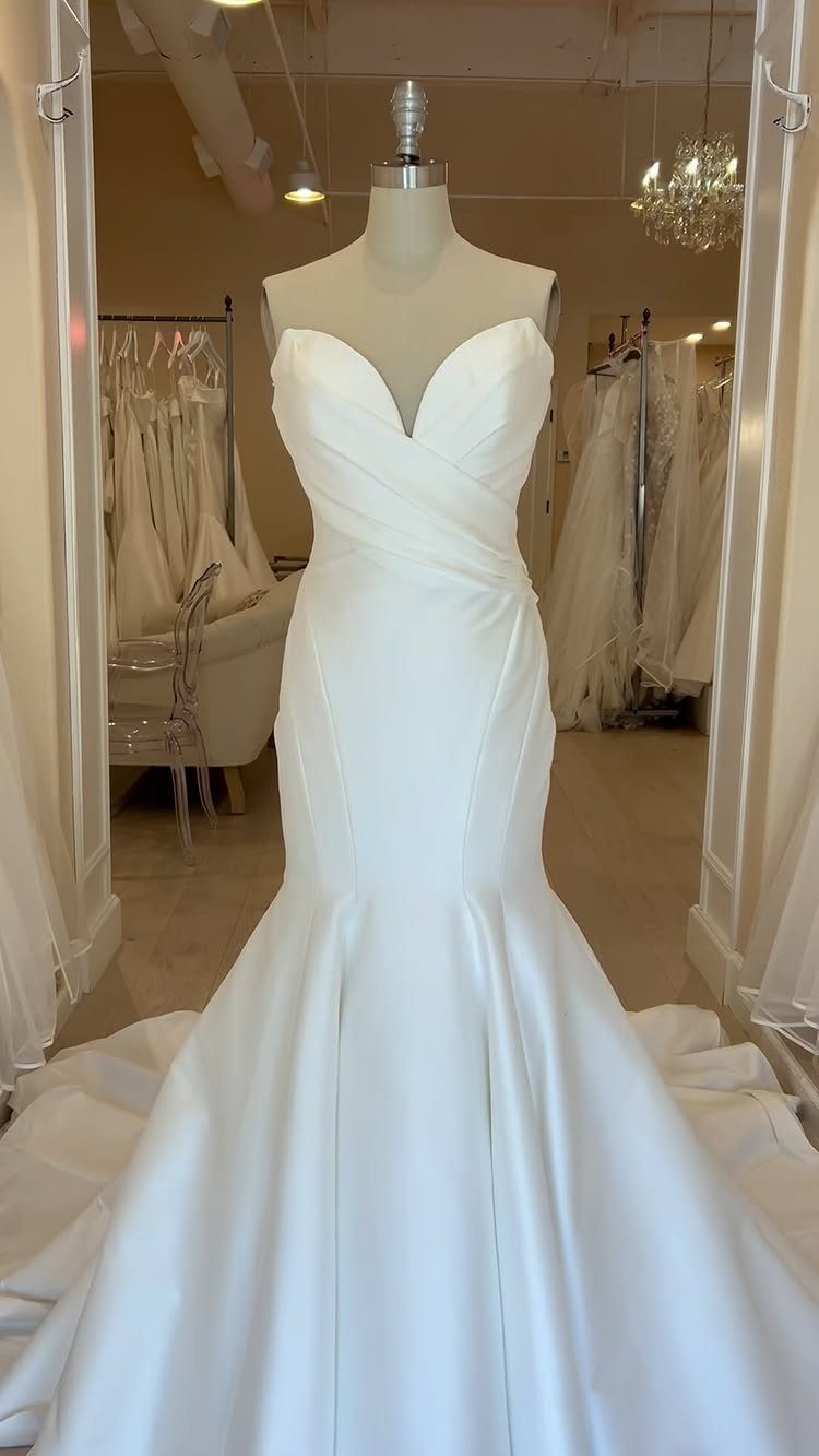 White mermaid wedding dress with sweetheart neckline on a mannequin in a bridal shop