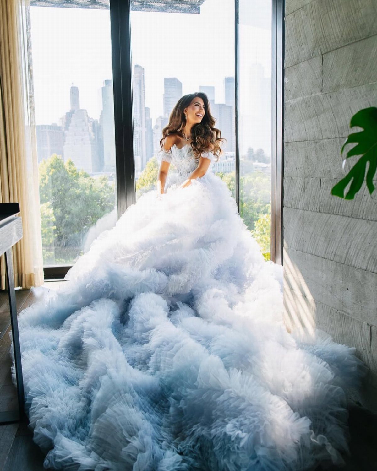 Woman in a light blue gown with a sweetheart neckline and ruffled tulle skirt.