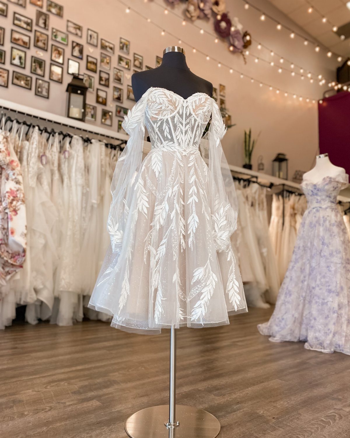 Short white wedding dress with sweetheart neckline and leaf embroidery on a mannequin.