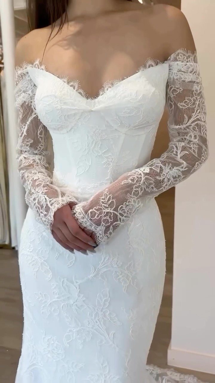 White lace wedding dress with sweetheart neckline and long sheer lace sleeves.