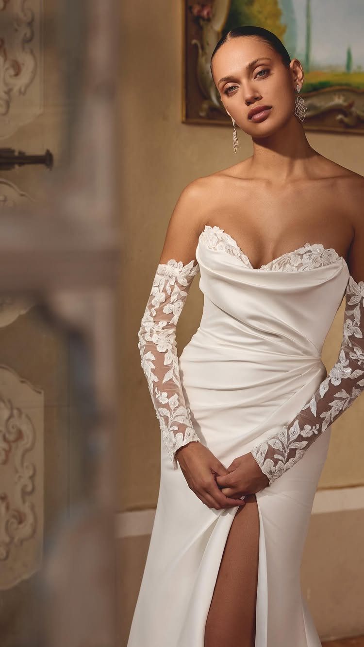 Woman in a white sweetheart wedding dress with lace sleeves and a high leg slit
