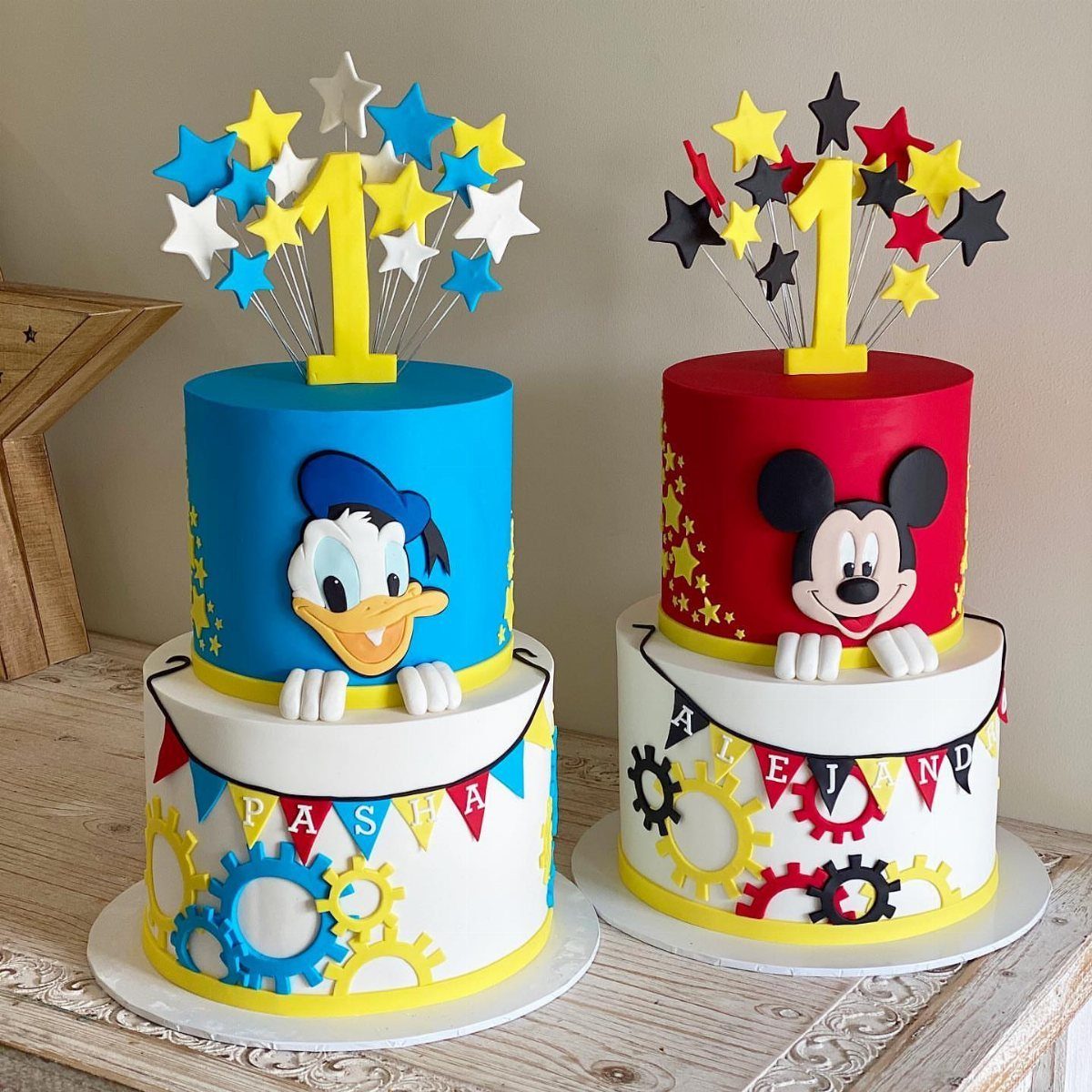 Two tiered birthday cakes featuring Donald Duck and Mickey Mouse with number one toppers.