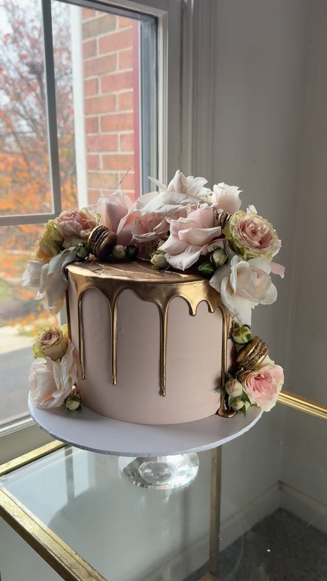 Blush pink cake with gold ganache drip and fresh pink and white roses.