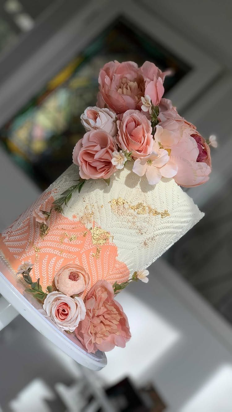 37 Wedding Cakes with Flowers to Inspire Your Design 35 White textured cake decorated with pink and peach roses and gold leaf accents.