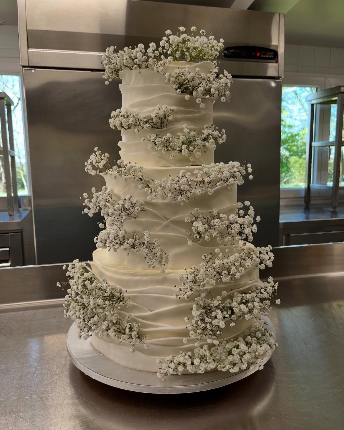 37 Wedding Cakes with Flowers to Inspire Your Design 27 Multi-tiered white wedding cake decorated with abundant clusters of white gypsophila flowers.