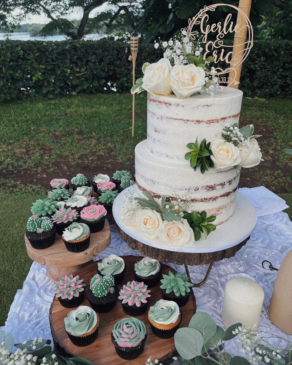 37 Wedding Cakes with Flowers to Inspire Your Design 7 Two-tier semi-naked wedding cake with white roses and green succulents on wooden platters.