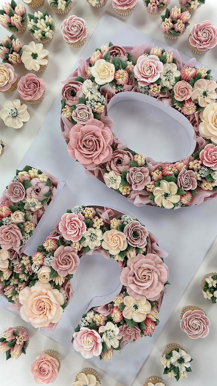 Number 50 cake made of dusky pink and pale green frosting flowers.
