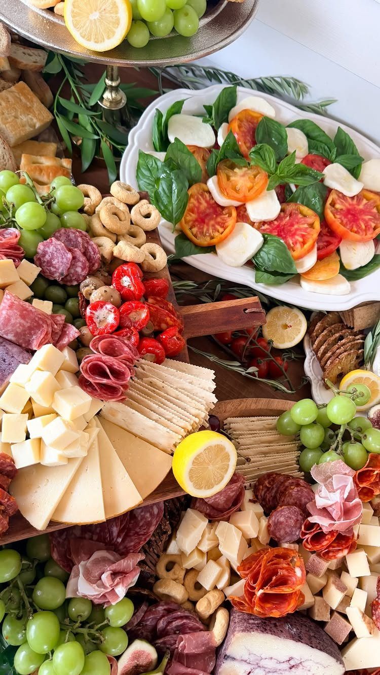 Italian antipasto spread with Caprese salad, cured meats, cheeses, and fresh grapes.